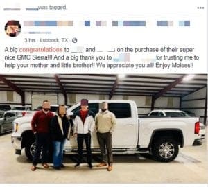 People pose in front of a truck
