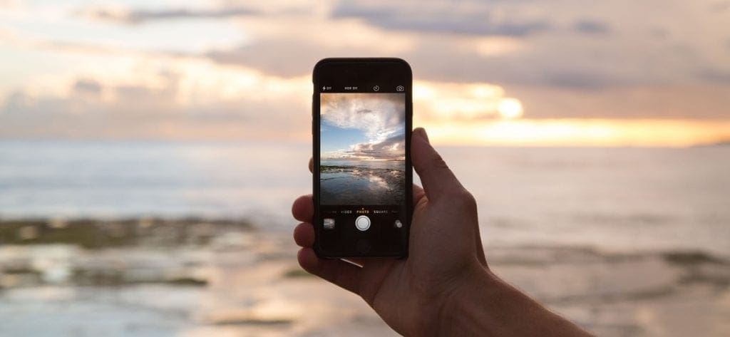 smartphone capturing sea view